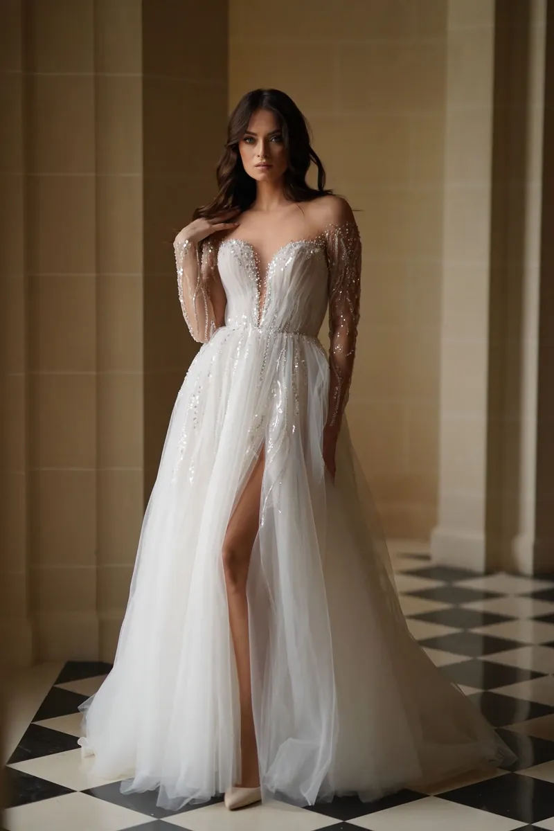 Robe Séléstia Alexandra fendue en tulle, manches longues en dentelle, dans un salon à damier