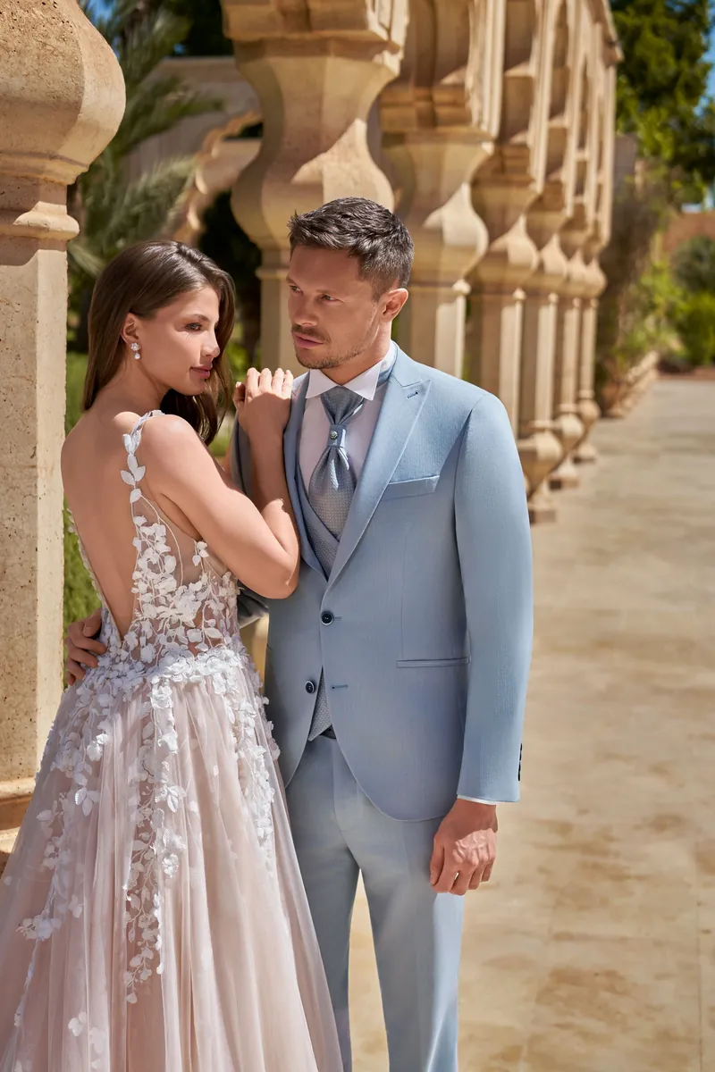 Mariée en robe de dentelle et marié en costume bleu ciel