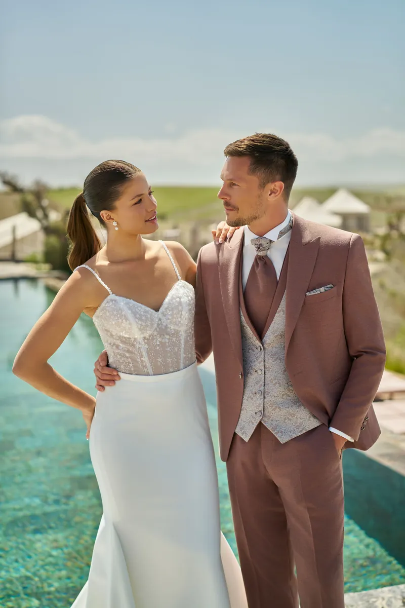 Couple au bord d’une piscine : robe sirène et costume marron